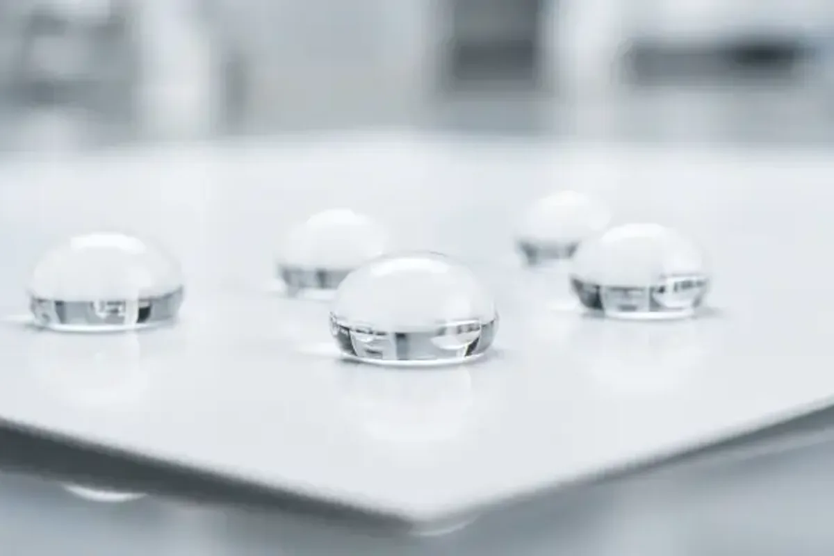 Water droplets beading on a coated test panel for Cobb water-resistance screening.