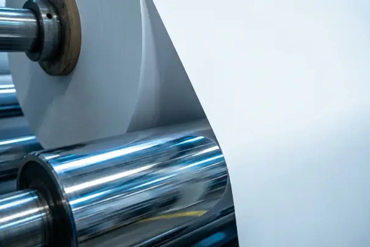 Heat-seal coated roll stock moving through rollers during non-blocking validation.