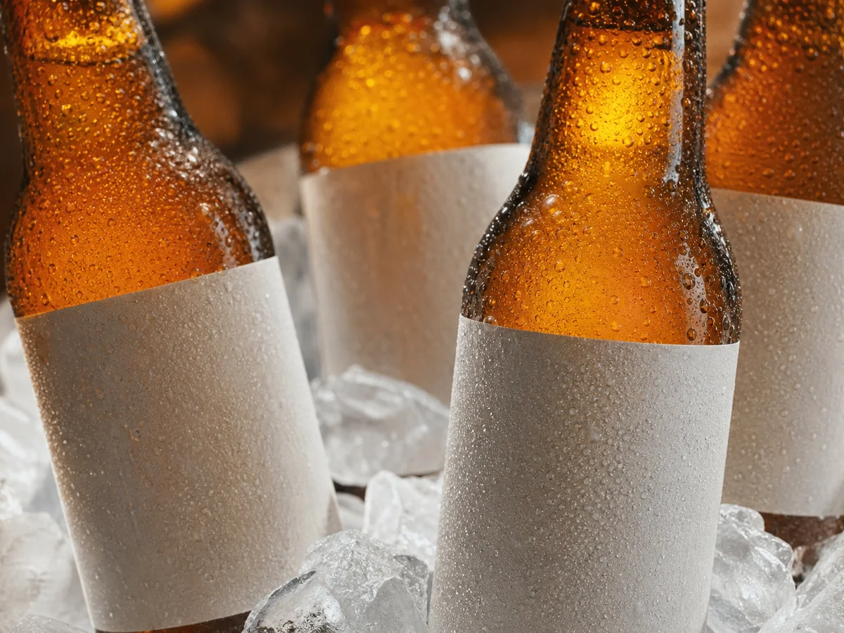 Beer bottles with condensation showing labels adhered to cold glass in high-humidity service.