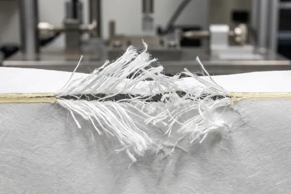 Tyvek and paper envelope destructive-bond test showing fiber tear and high-adhesion security adhesive performance.